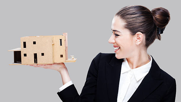 istock Female business agent holding house model 485525464