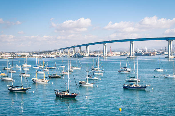 San Diego waterfront with sailing Boats San Diego waterfront with sailing Boats - Indutrial harbor and Coronado Bridge marina california stock pictures, royalty-free photos & images