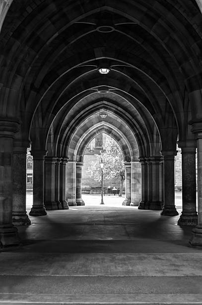 Arcades of old Glasgow University corridor cloisters. Scotland. Monochrome image. Arcades of old Glasgow University corridor cloisters. UK, Scotland. Black and white image. cloister stock pictures, royalty-free photos & images