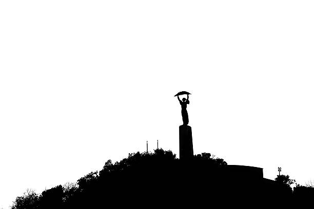 Liberation Monument in Budapest, Hungary Silhouette of the Liberation Monument (Szabadság Szobor) in Budapest, Hungary, a 46 for tall statue erected in Gellert Hll as a symbol of peace. gellert stock pictures, royalty-free photos & images