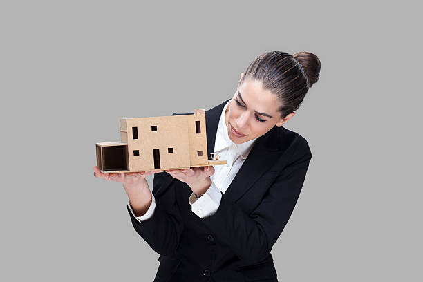 istock Female business agent holding house model 485531862