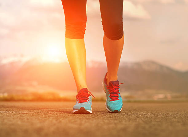 istock Runner athlete feet running on road under sunlight. 485532024