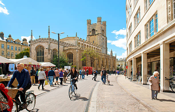 Cambridge Cambridge, England - May 28, 2015: People biking at the Market square near by St. Marys church in Cambridge  cambridge england photos stock pictures, royalty-free photos & images