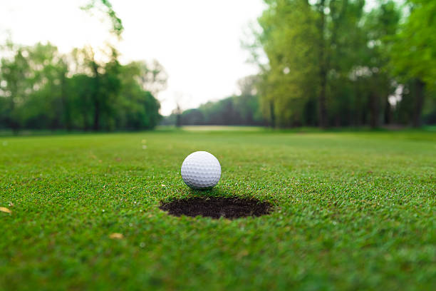 istock golf ball on lip of cup. 485537435