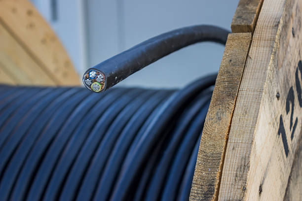 Roll of black industrial al cable with cross section on wooden reel