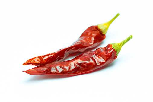 Dried chili peppers on white background.