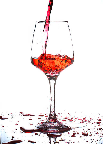 istock red wine pouring into wine glass isolated on white 485541080