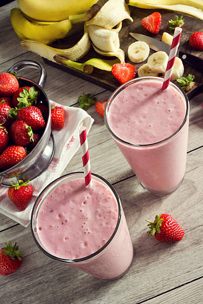 istock Two Strawberry Banana Yogurt Smoothies in Glasses with Ingredients 485541362