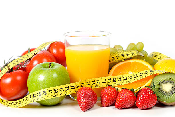 istock fresh fruit , vegetables and orange juice wrapped in measure tape 485543675