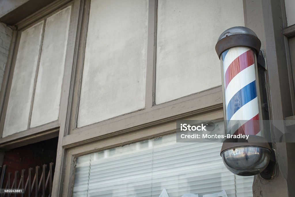 American Barber Pole Barber Pole in small town Americana. Daylight. Frame to allow for Copy Space. Few items are as unique in delivering a message as the classic American Barber Pole. Barber Shop Stock Photo