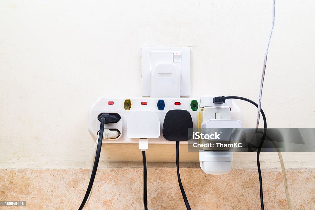 Multiple electricity plugs attached to multi adapter is dangerou Multiple electricity plugs attached to multi adapter is dangerous. Electric Plug Stock Photo