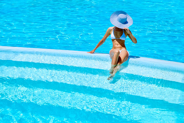 istock woman relaxing at a resort swimming pool 485549190