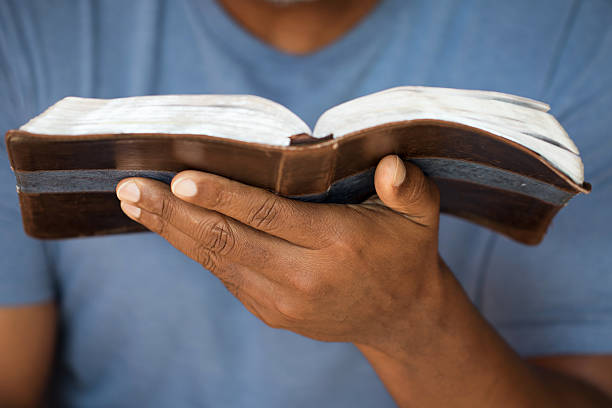 hombre que agarra un biblia - reading religious text black bible fotografías e imágenes de stock
