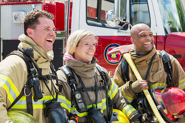 istock Firefighters in protective gear with fire rescue trucks 485557818