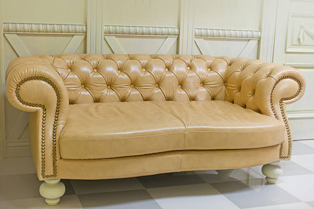 istock Yellow vintage sofa on white wall 485557958