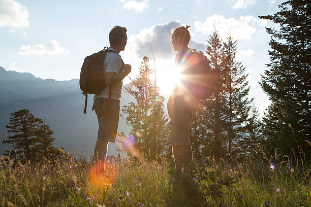 istock Two hikers watch sunrise from mountain meadow 485558116