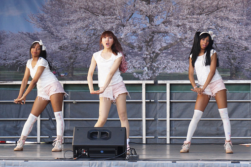 Washington DC, USA-April, 12, 2014:  These three teenage girls perform Japanese pop music on the stage at the 54th Annual Sakuri Matsuri Japanese Street Festival in Washington DC.   This festival features arts and crafts, food and entertainment and is part the Cherry Blossom Festival.