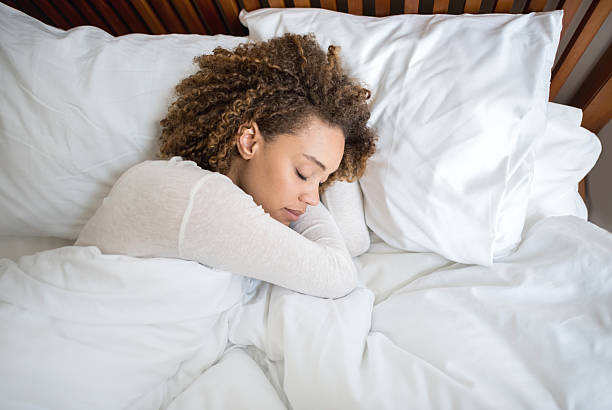 afroamericana mujer durmiendo en la cama - colchones fotografías e imágenes de stock