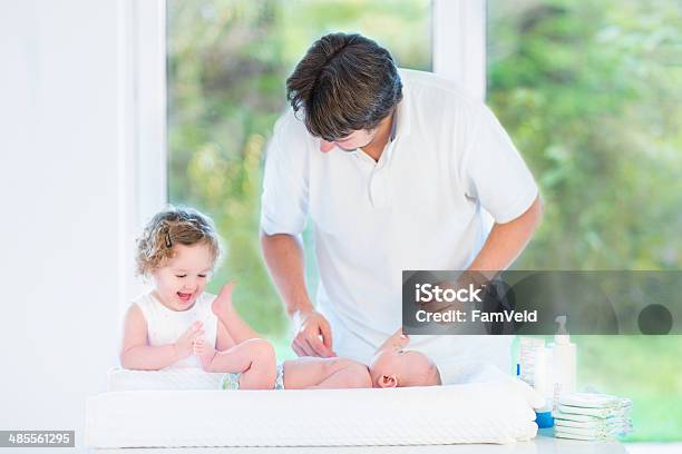 Newborn Baby Looking At His Father And Sister Changing Diaper Stock Photo - Download Image Now