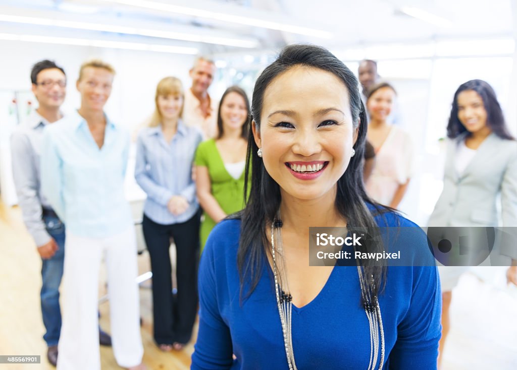 Beautiful woman with colleagues in the background Community Stock Photo