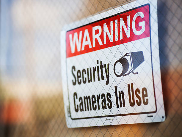 Security Cameras in Use Generic sign warning about security cameras in use, hanging in a window. surveillance camera sign stock pictures, royalty-free photos & images