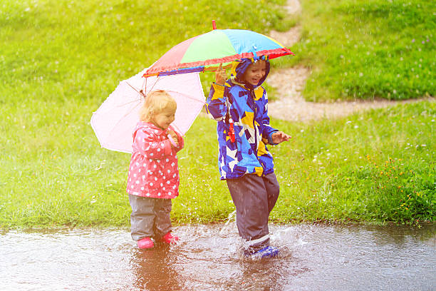 istock little boy and girl having fun on rain 485562786