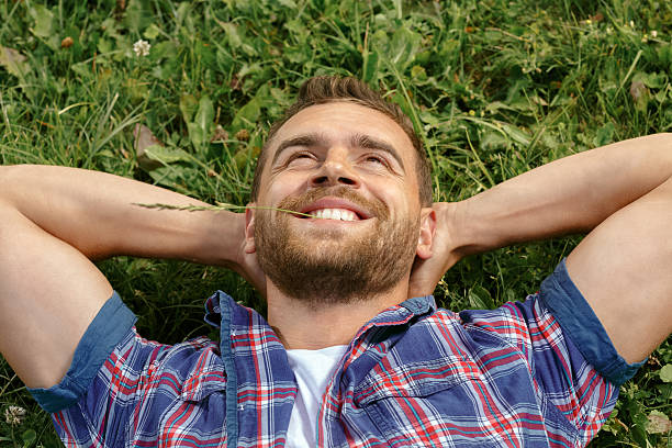 istock Handsome man lying on the grass in park 485562920