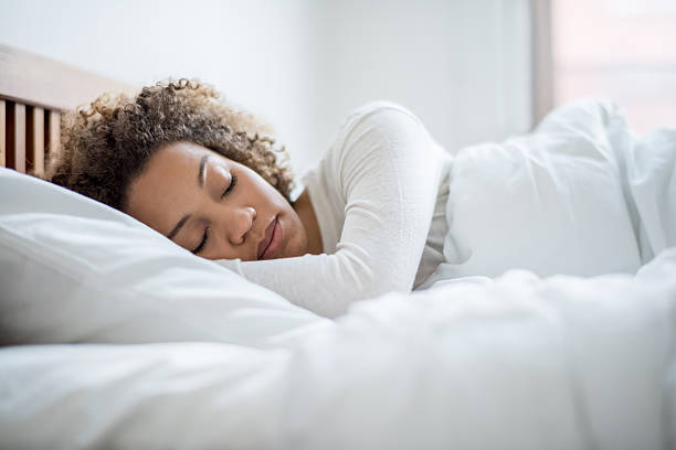 schwarze frau schläft im bett - tranquil scene sleeping clothing expressing positivity stock-fotos und bilder