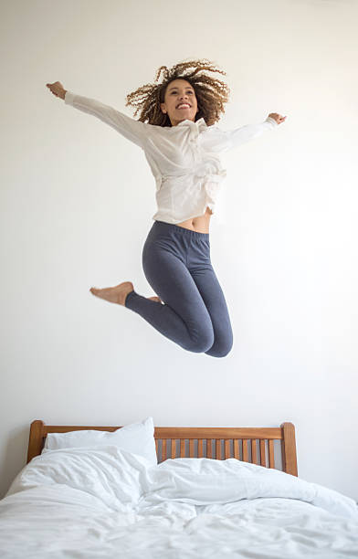 istock Excited woman jumping on the bed 485563414