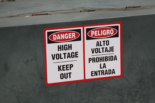 An electrical warning sign in both English and Spanish