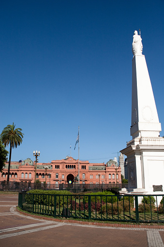 Buenos Aires, Argentina - December 25, 2010: Located in the city´s historic government district,  Argentina´s oldest national monument, the Pyramide de Mayo is crowned by a Liberty symbol that celebrates the Country´s Independence. In the background we can see Casa Rosada, Argentina´s Government Seat in Buenos Aires. Built around 1594, it´s the most important Government Building in Argentina, South America.
