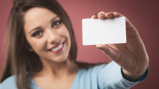 istock Smiling girl with business card 485572512