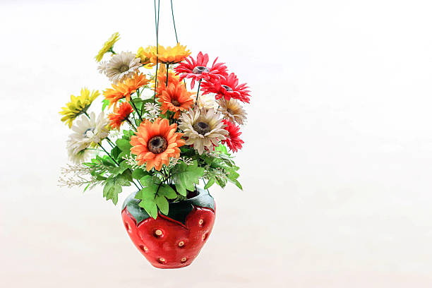 istock artificial flowers in strawberry vase hanging on white 485574366