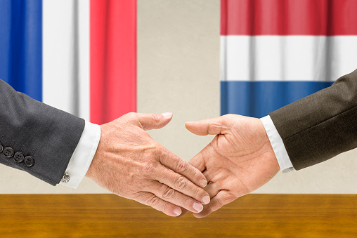 Representatives of France and the Netherlands shake hands