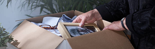 Woman packing dead husband's photography Woman packing dead husband's photography to moving box souvenir stock pictures, royalty-free photos & images
