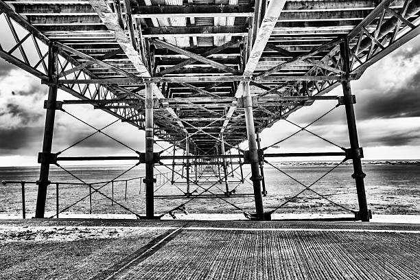 Play of light and deep shadows emphasizes the textures of the weathered wood and the architectural structure of coastal architecture
