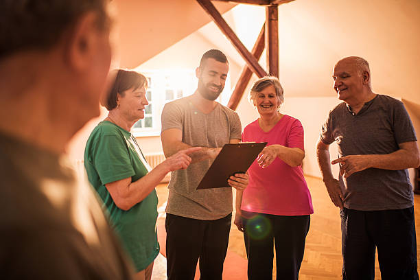 istock Young coach making an exercise plan for group of seniors. 485576710
