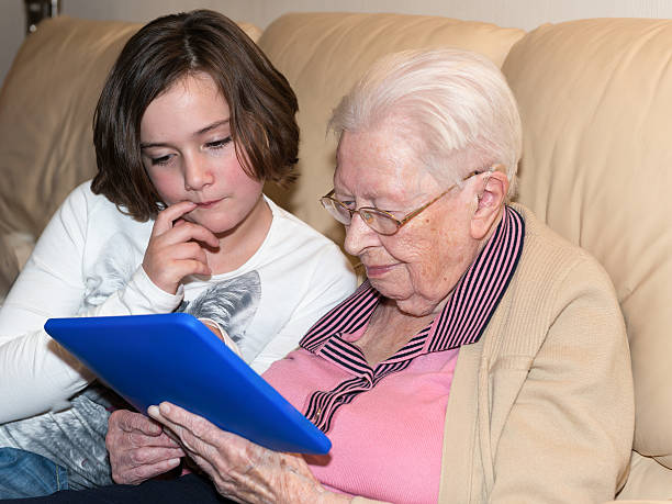 istock Old woman and young girl with tablet-pc 485582675