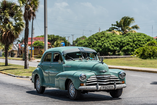 Varadero, Cuba - July 3, 2015: American green classic car drives in the sunshine on the street in Varadero Cuba