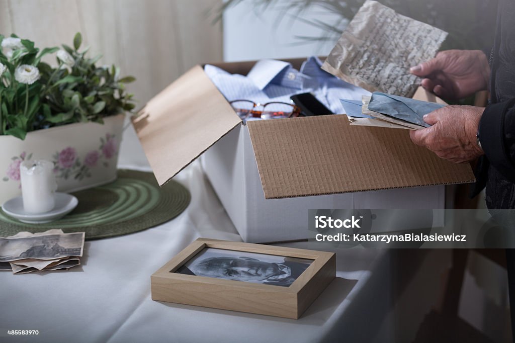 Packing remembrances after dead husband Woman in mourning packing remembrances after dead husband Box - Container Stock Photo