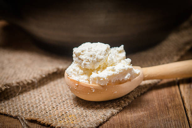 istock Fresh cottage cheese in a wooden spoon 485584134