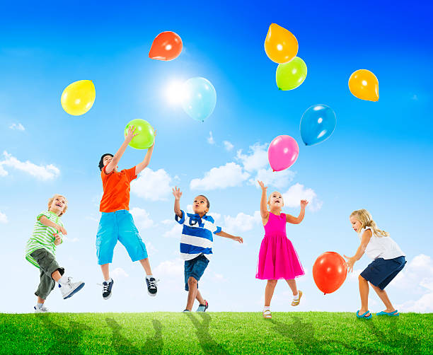 A bunch of balloons are on the ground. There are three red balloons and two yellow balloons. The balloons are in a diamond shape