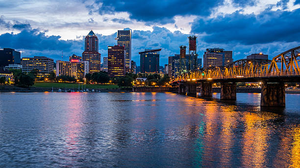 Portland Skyline Along Willamette River Colorful lights reflecting off the Willamette River in Downtown Portland, Oregon portland oregon photos stock pictures, royalty-free photos & images