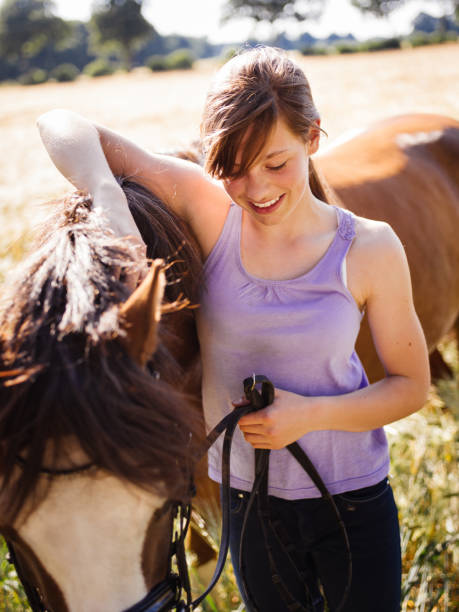 istock Girl lovingly rubbing her horse's mane in a field 485587108