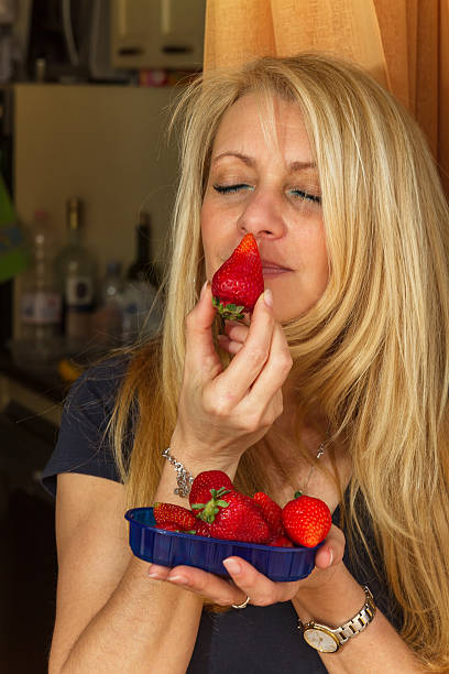 istock Blonde woman sniffing a strawberry 485588056