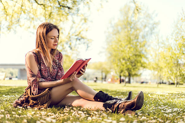 istock Woman sitting in the park and reading a book. 485588414