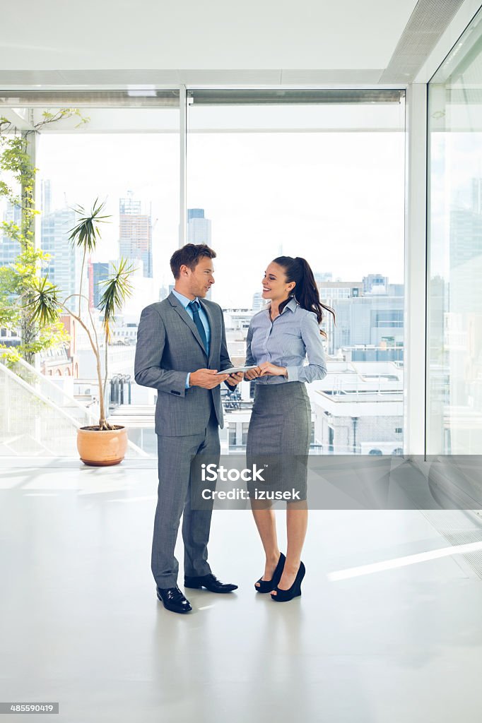 Business couple Full lenght portrait of two business people discussing in the office.  Luxury Stock Photo