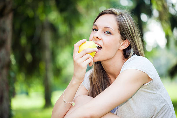istock Woman eating an apple in the park 485591462