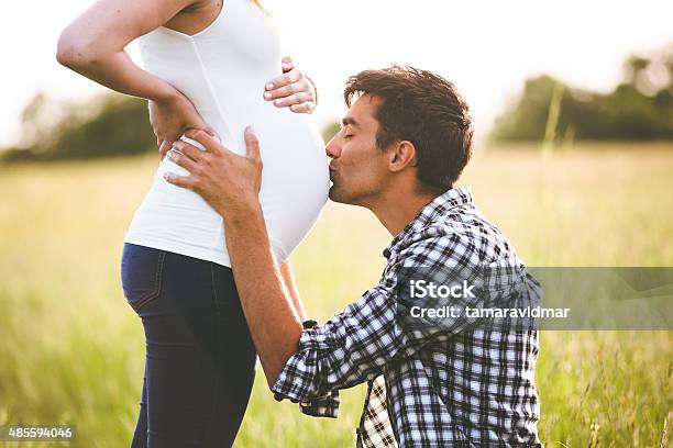 Young Man Kissing The Belly Of His Pregnant Woman Stock Photo - Download Image Now - Pregnant, Couple - Relationship, Two Parents
