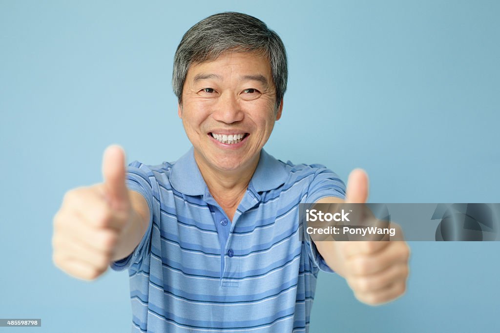 Happy man show thumb up Happy elderly man smile to you and  show thumb up, asian Blue Background Stock Photo